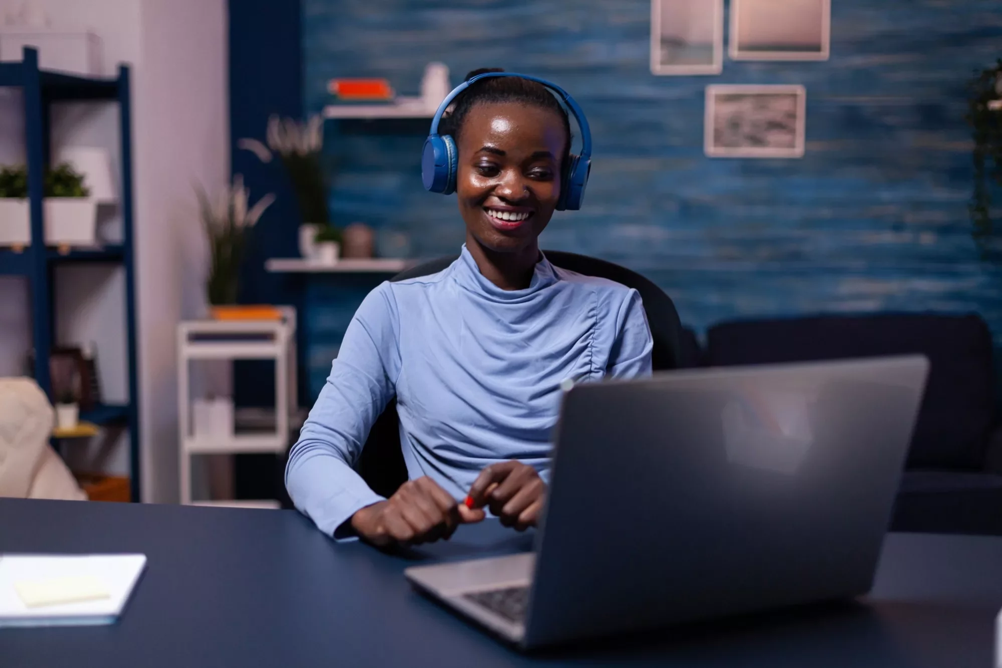 black-woman-good-mood-wearing-headset-listening-music-working-deadline-from-home-office-sitting-desk-african-freelancer-creating-new-project-working-late