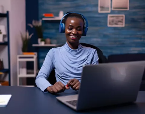 black-woman-good-mood-wearing-headset-listening-music-working-deadline-from-home-office-sitting-desk-african-freelancer-creating-new-project-working-late